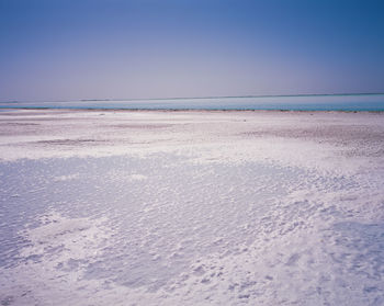 Scenic view of beach against clear blue sky