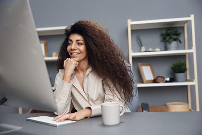 Young woman using mobile phone at table