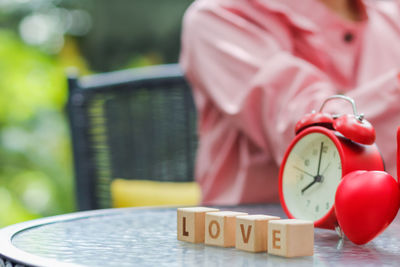 Close-up of clock with wooden blocks on table