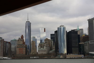 Modern buildings in city against cloudy sky