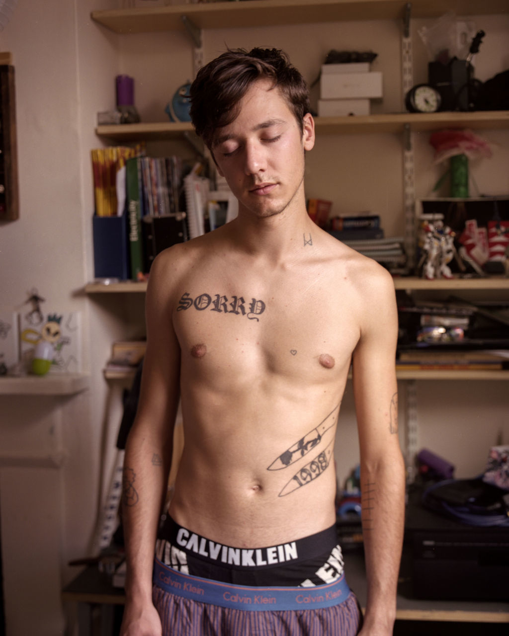 one person, young adult, shirtless, young men, lifestyles, standing, front view, indoors, real people, waist up, home interior, tattoo, portrait, leisure activity, looking at camera, handsome, men, masculinity