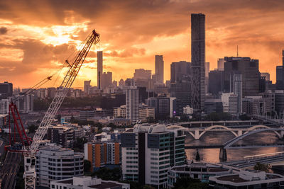 Modern buildings in city against sky during sunset