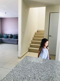 Woman sitting on staircase at home