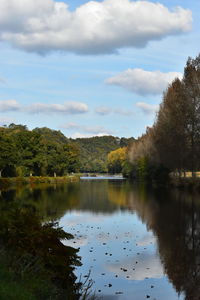 Scenic view of lake by trees against sky