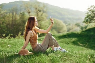 Side view of woman sitting on field