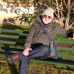 Portrait of woman sitting on bench in park