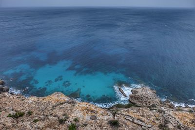 High angle view of rocks by sea against sky