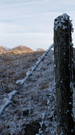 Wooden post on snow covered land