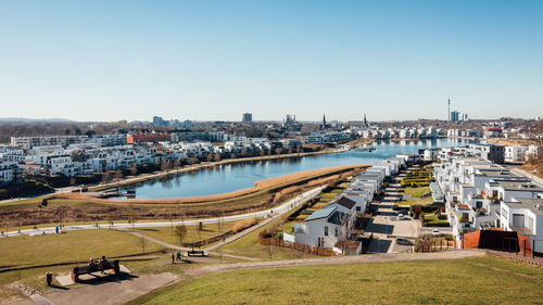 High angle view of river amidst buildings against clear sky