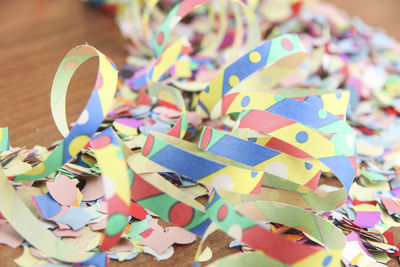 Close-up of colorful confetti on wooden table