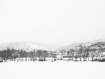 Snow covered landscape against clear sky