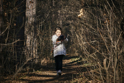 Cute girl walking on footpath in forest