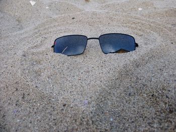 High angle view of sunglasses on sand