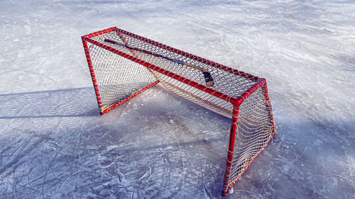 Outdoors ice rink with hockey goal and hockey stick