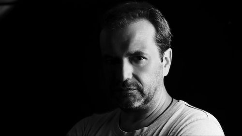 Close-up portrait of young man against black background