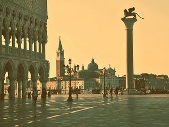 Tourists in front of mosque against sky