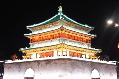 Low angle view of illuminated building against sky at night