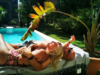 Low section of woman relaxing in swimming pool