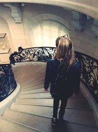 Rear view of woman standing on steps