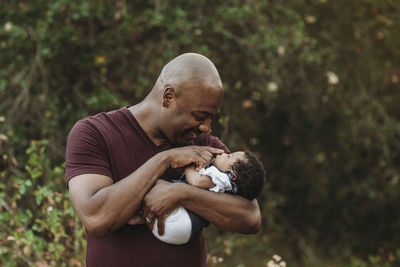 Close up happy father holding and smiling at newborn