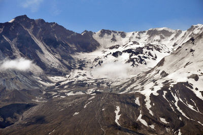 Scenic view of mountains against cloudy sky