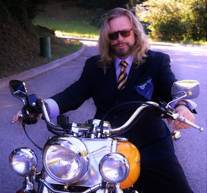 Portrait of man riding harley davidson motorcycle on road