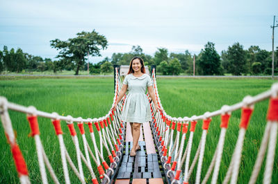 Portrait of smiling woman standing on footbridge