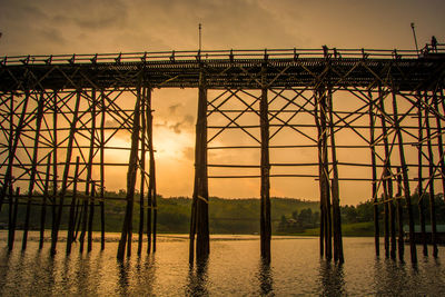 Bridge over river against sky during sunset