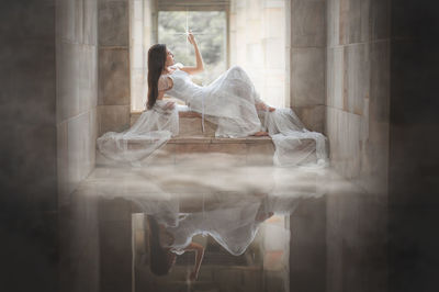 Female model posing at window sill