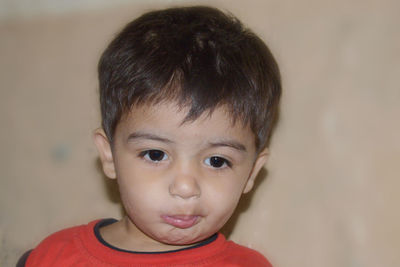 Close-up of cute baby boy against wall