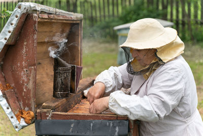 Beekeeper working with smoker at park