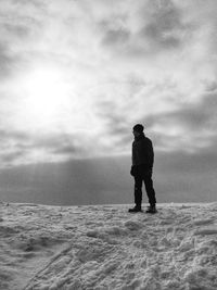 Silhouette man standing on sea shore against sky