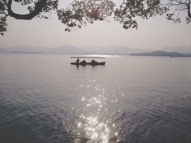 water, lake, tranquility, mountain, transportation, tranquil scene, nautical vessel, waterfront, scenics, silhouette, boat, mode of transport, beauty in nature, nature, rippled, sky, tree, reflection, river, sunset