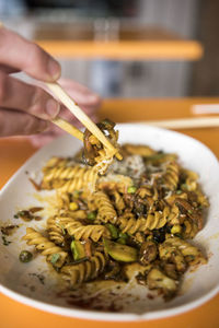 Midsection of person holding noodles in plate