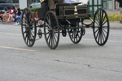 Low section of man on motor buggy over street during fourth of july parade