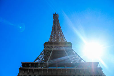 Low angle view of illuminated tower against blue sky