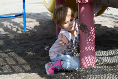 Cute girl playing on sand at beach