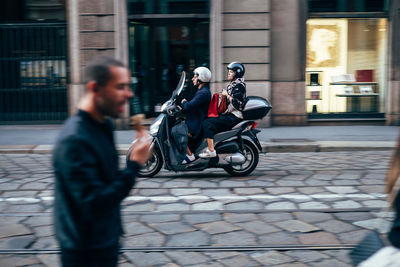 Man riding motorcycle on street in city