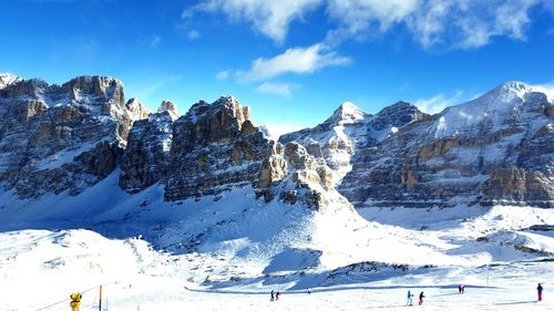 Low angle view of snow covered mountains against sky