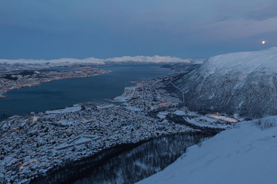 Town by fjord against sky seen from mountain peak