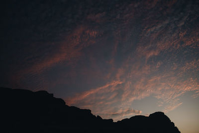 Low angle view of silhouette mountain against sky at sunset