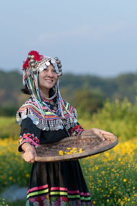 Woman holding umbrella standing on field