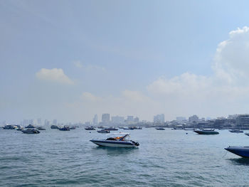 Boats in sea against buildings in city