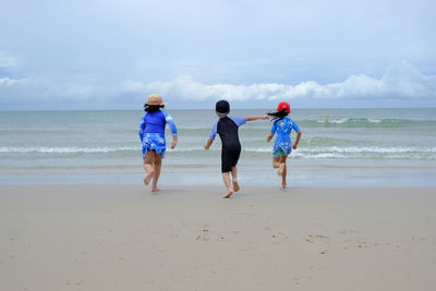 Happy children playing water on beach