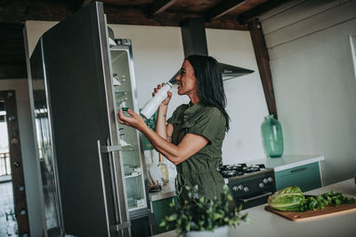 Side view of woman having food at home