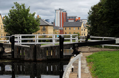 Bridge over canal amidst buildings against sky