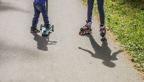 Low section of children roller skating on road