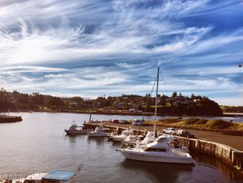 High angle view of boats moored at harbor against cloudy sky