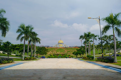 View of palm trees outside temple against sky