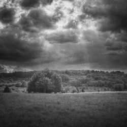 Scenic view of grassy field against cloudy sky